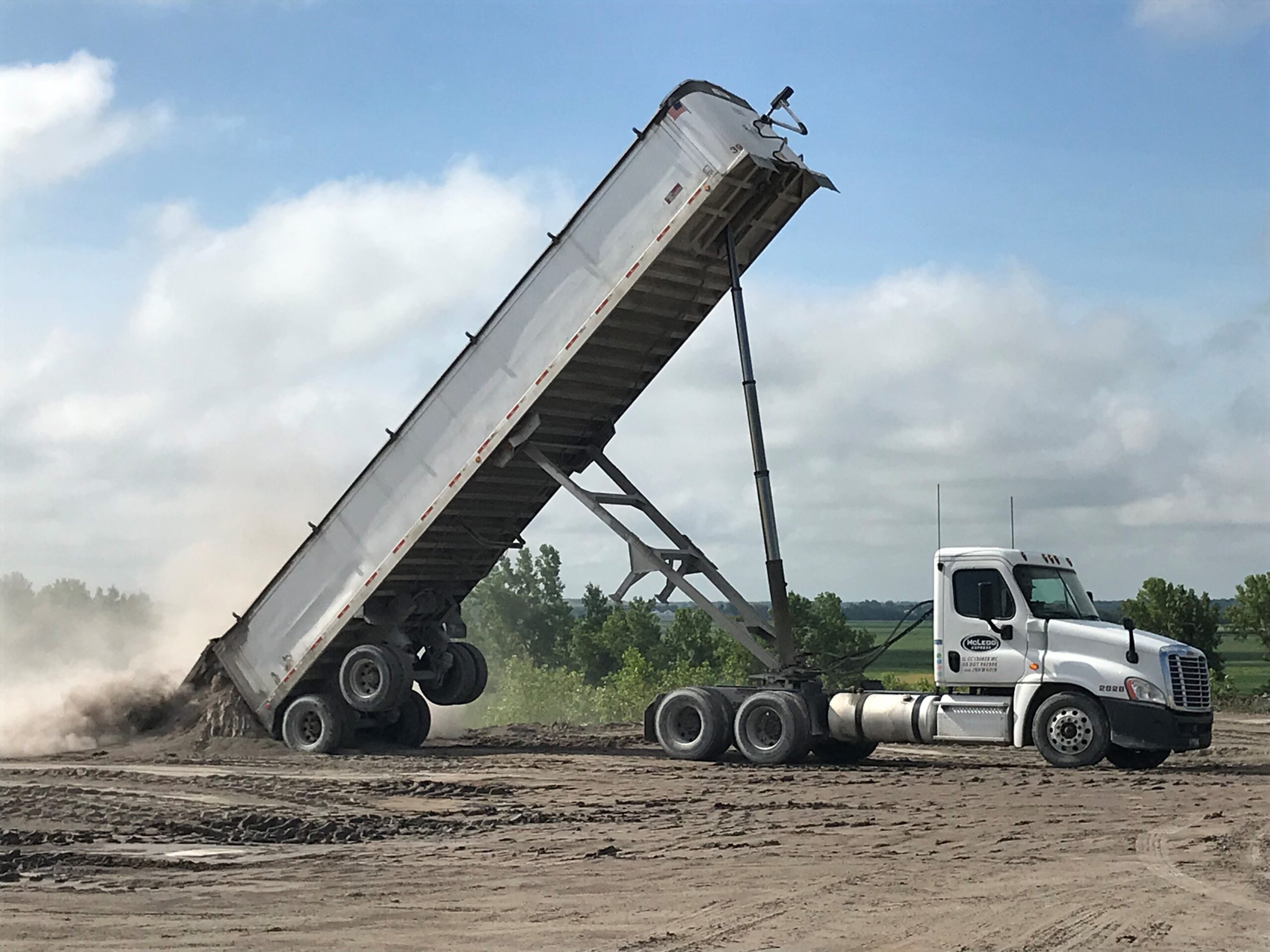 McLeod Express Dump truck, showing the trailer fully elevated to dump it's contents out.